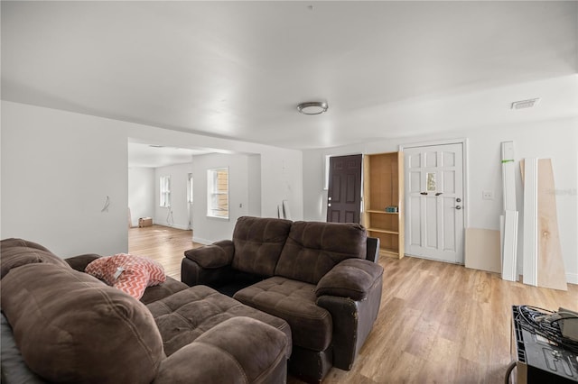 living room with light wood-style flooring and visible vents