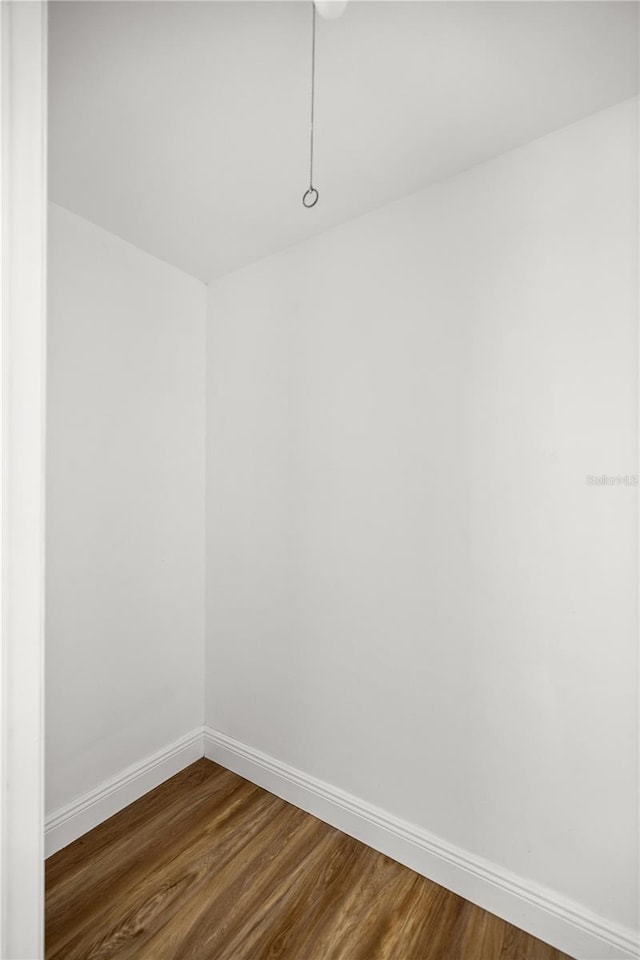 empty room featuring dark wood-style flooring and baseboards