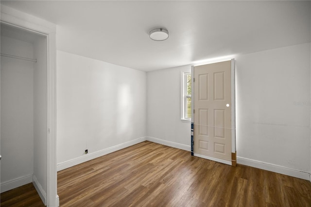 entrance foyer featuring baseboards and dark wood-type flooring