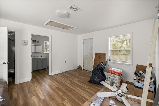 interior space featuring visible vents, multiple windows, wood finished floors, and attic access