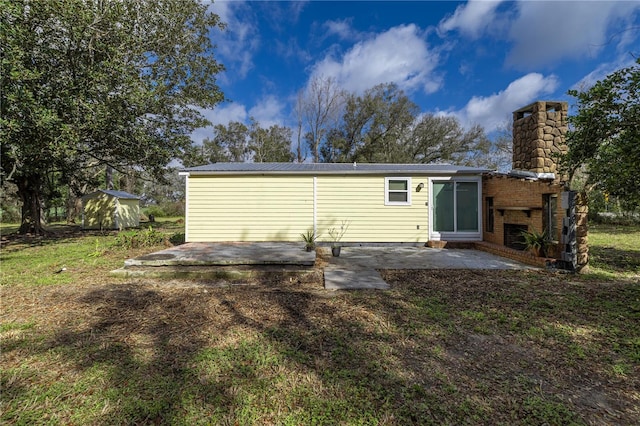 rear view of property featuring metal roof, a chimney, and a patio area