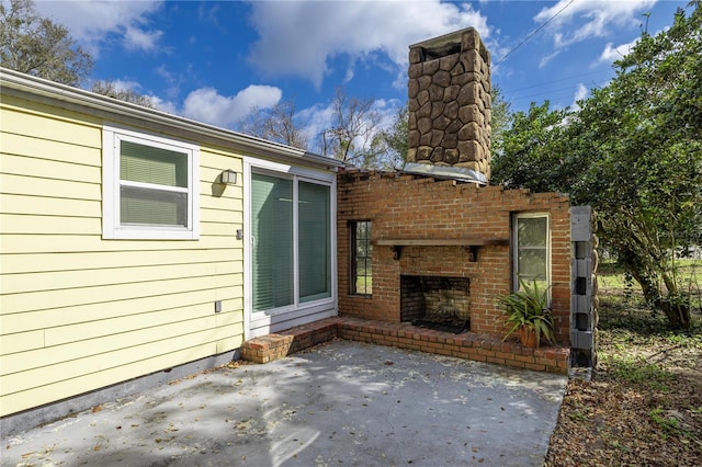 view of patio featuring an outdoor brick fireplace