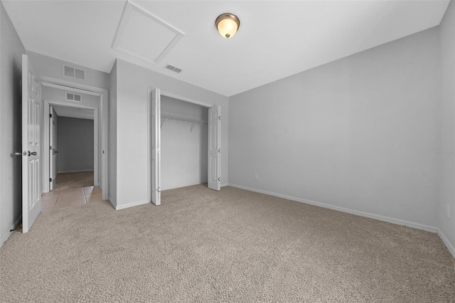 unfurnished bedroom with a closet, visible vents, and light colored carpet