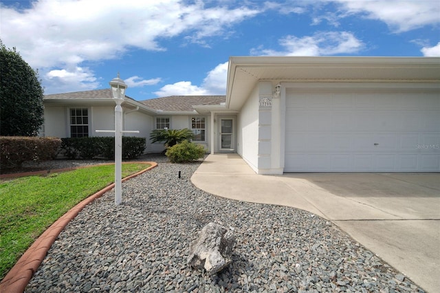 ranch-style home with an attached garage, driveway, and stucco siding