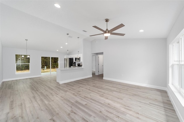 unfurnished living room with light wood-style floors, vaulted ceiling, baseboards, and ceiling fan with notable chandelier