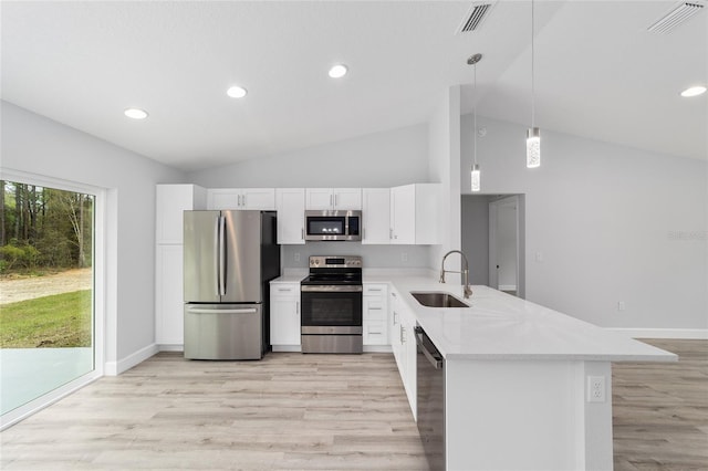 kitchen with visible vents, a peninsula, stainless steel appliances, light countertops, and a sink