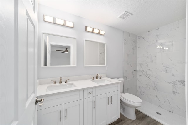 full bath featuring double vanity, visible vents, a sink, and wood finished floors