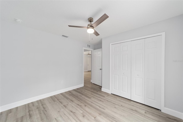 unfurnished bedroom featuring light wood finished floors, a closet, visible vents, a ceiling fan, and baseboards