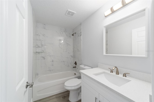 bathroom with visible vents, toilet, wood finished floors, a textured ceiling, and vanity