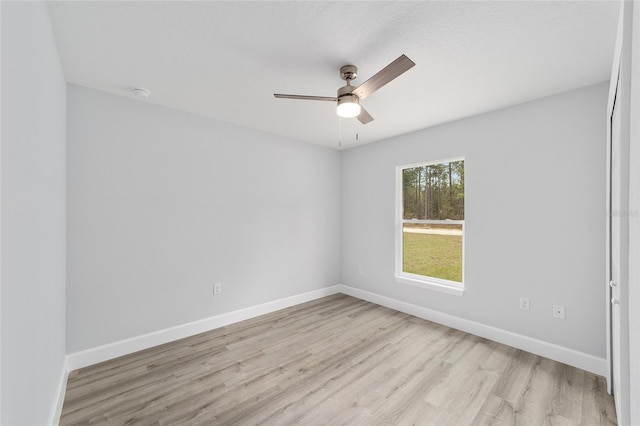 spare room with light wood-style flooring, baseboards, and ceiling fan