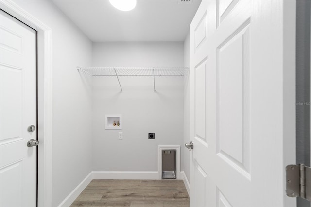 laundry area featuring hookup for a washing machine, light wood-style floors, hookup for an electric dryer, laundry area, and baseboards