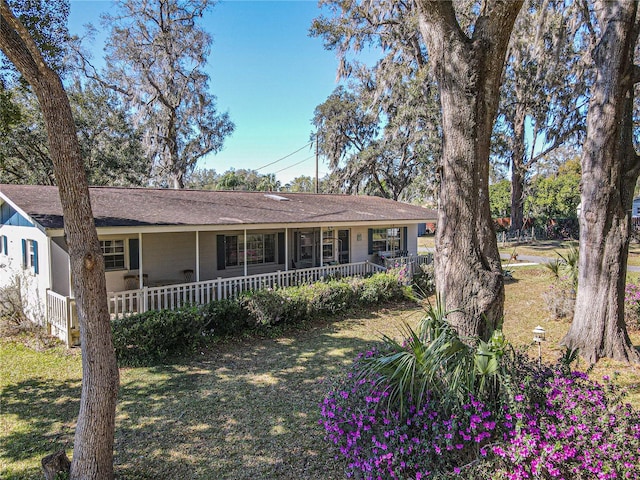 ranch-style home featuring a porch and a front yard