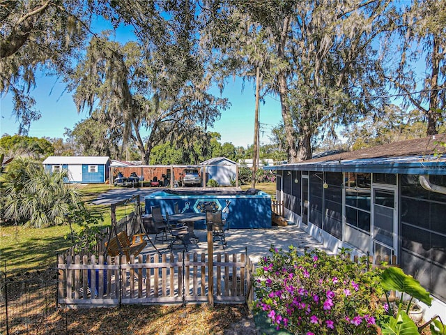 view of swimming pool featuring a patio, fence, and a sunroom