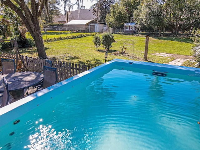 view of pool featuring fence and a lawn