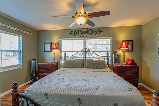 bedroom with ceiling fan, wood finished floors, and baseboards