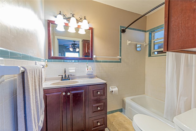 full bathroom with shower / tub combo, wainscoting, toilet, vanity, and tile walls