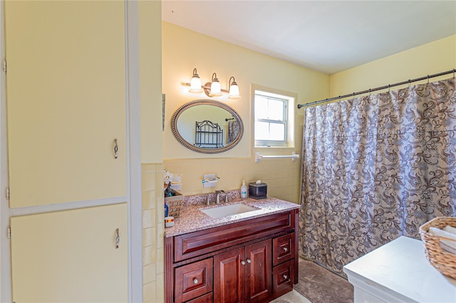 full bathroom with a wainscoted wall, a shower with curtain, tile walls, and vanity