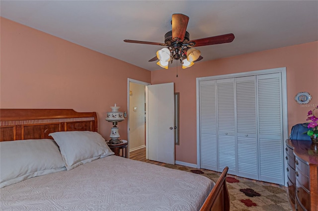 carpeted bedroom featuring a closet, ceiling fan, and baseboards