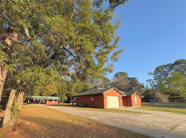 exterior space with a garage, concrete driveway, and a front lawn