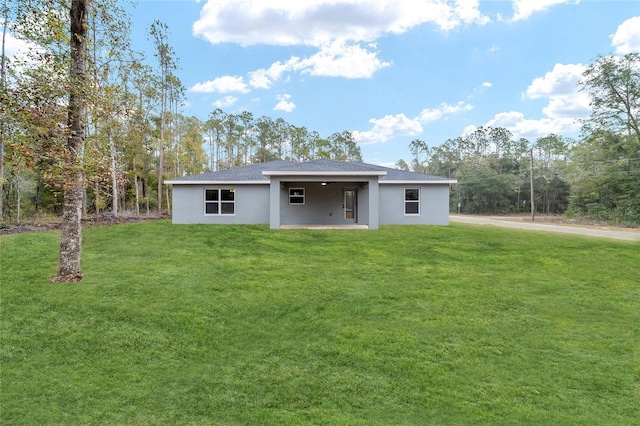 back of house featuring a lawn, a wall mounted air conditioner, and stucco siding