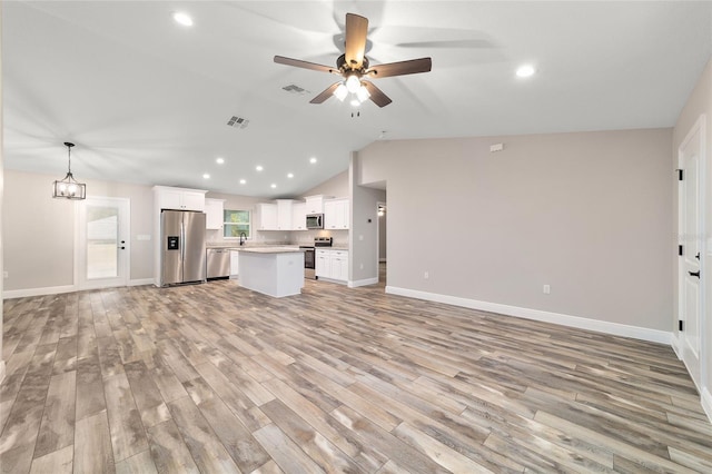 unfurnished living room with lofted ceiling, light wood-style floors, visible vents, and ceiling fan with notable chandelier