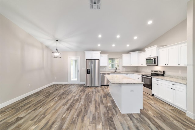 kitchen featuring visible vents, white cabinets, appliances with stainless steel finishes, pendant lighting, and a sink