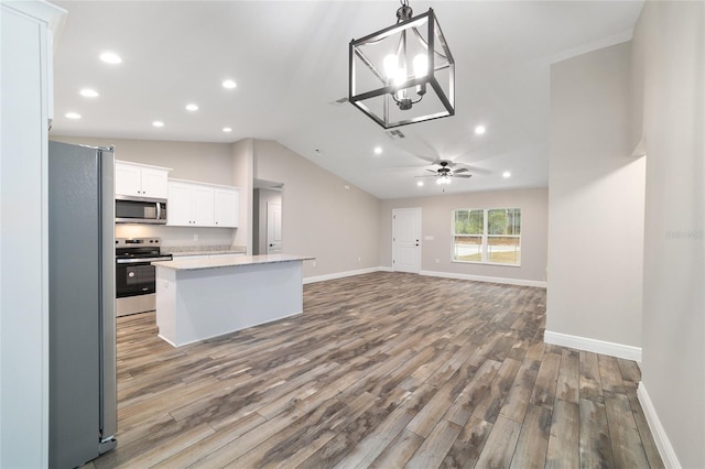 kitchen with white cabinets, appliances with stainless steel finishes, open floor plan, hanging light fixtures, and light countertops