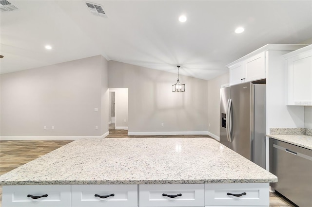 kitchen with visible vents, white cabinets, lofted ceiling, appliances with stainless steel finishes, and decorative light fixtures