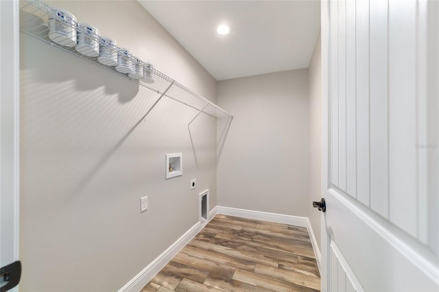 laundry area with laundry area, baseboards, wood finished floors, hookup for a washing machine, and hookup for an electric dryer