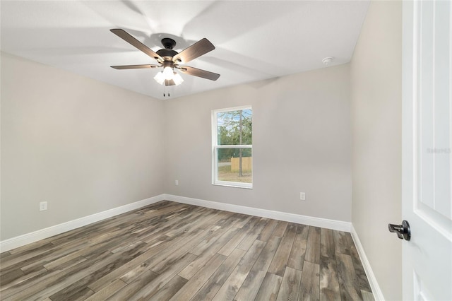 unfurnished room with a ceiling fan, baseboards, and wood finished floors