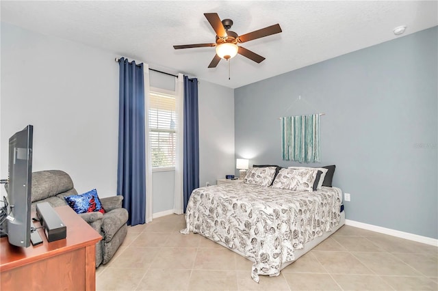 bedroom with a textured ceiling, ceiling fan, light tile patterned flooring, and baseboards