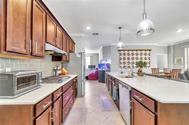 kitchen featuring decorative light fixtures, light countertops, appliances with stainless steel finishes, a sink, and under cabinet range hood