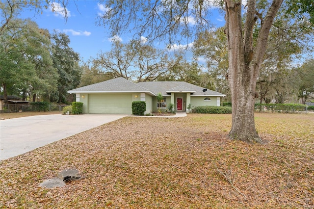 ranch-style house featuring concrete driveway, an attached garage, fence, and stucco siding