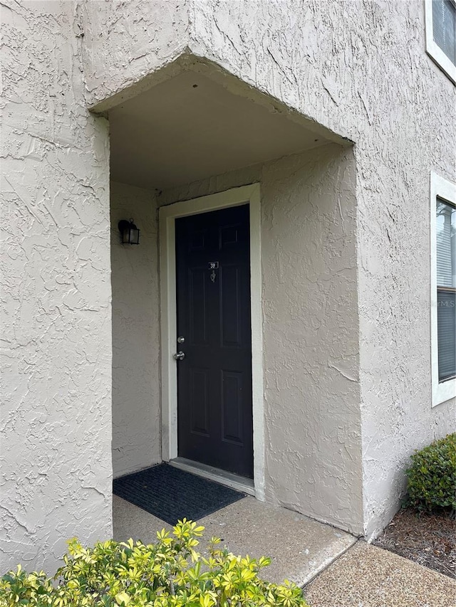 view of exterior entry featuring stucco siding