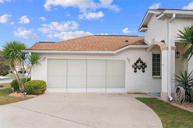 view of home's exterior featuring driveway, roof with shingles, and stucco siding