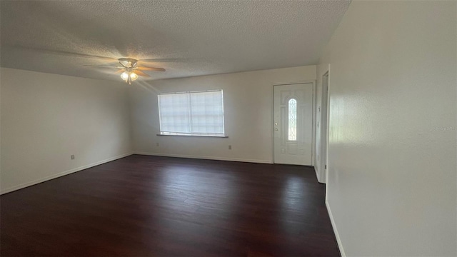 entrance foyer with a healthy amount of sunlight, dark wood-style floors, ceiling fan, and baseboards