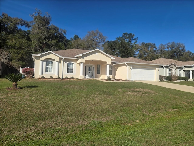 view of front of property with a garage, a front yard, driveway, and stucco siding