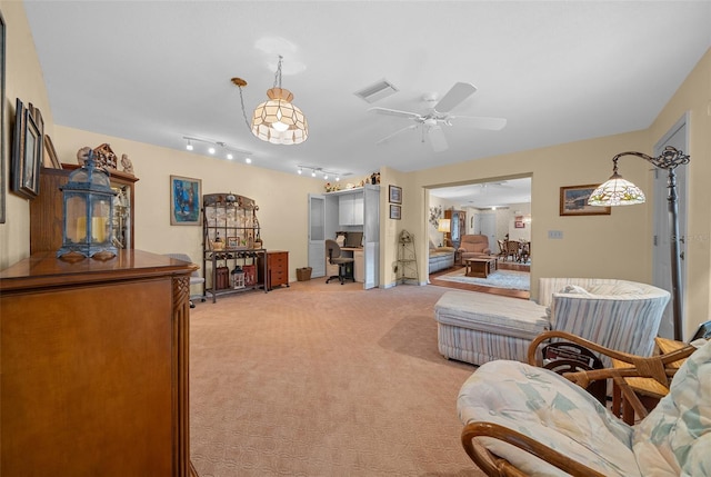 living room featuring rail lighting, ceiling fan, visible vents, and light colored carpet