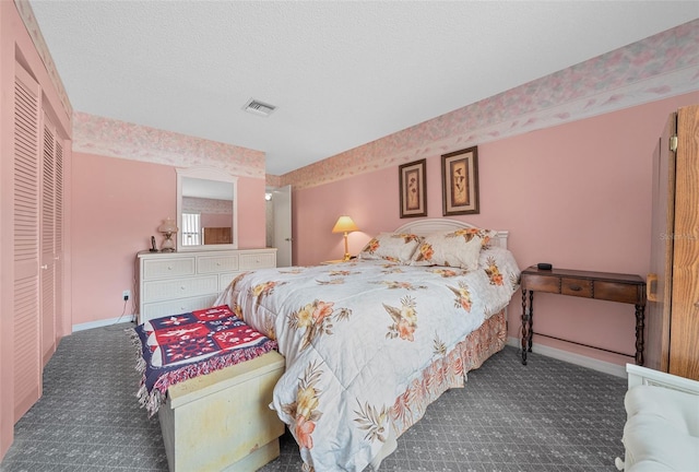 bedroom featuring dark colored carpet, a closet, visible vents, a textured ceiling, and baseboards