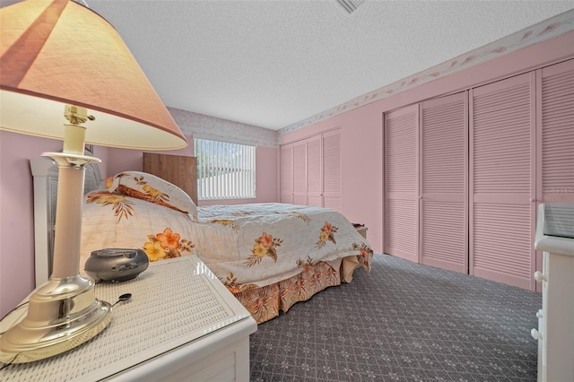 bedroom with multiple closets and a textured ceiling