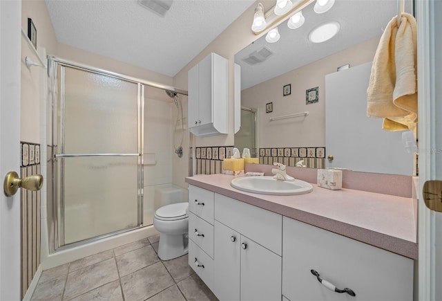 bathroom featuring a textured ceiling, a stall shower, vanity, and toilet
