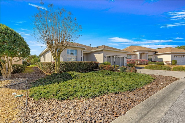 view of front facade with concrete driveway, an attached garage, and stucco siding