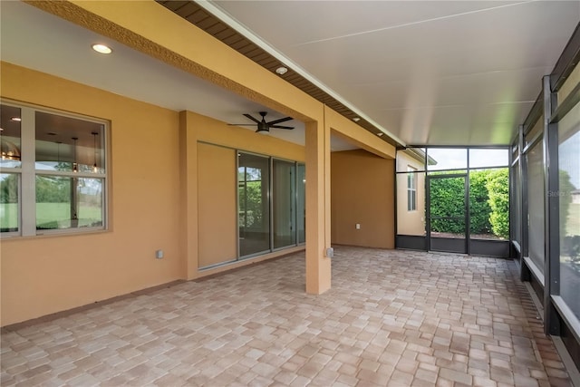 unfurnished sunroom with a ceiling fan