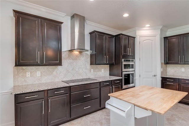 kitchen with double oven, black electric stovetop, dark brown cabinetry, and wall chimney exhaust hood