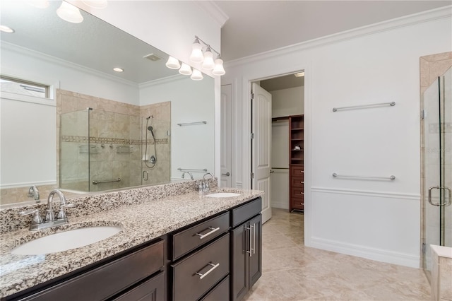 full bathroom with a shower stall, crown molding, and a sink