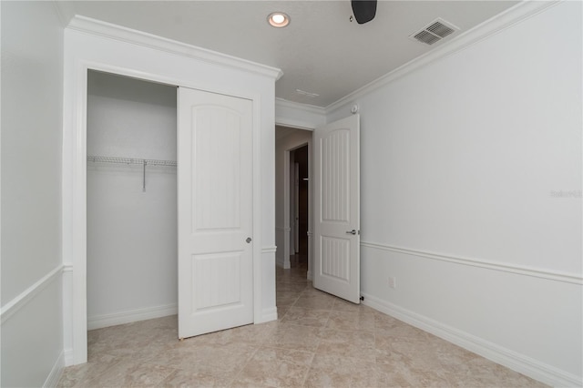 unfurnished bedroom featuring a closet, visible vents, crown molding, and baseboards