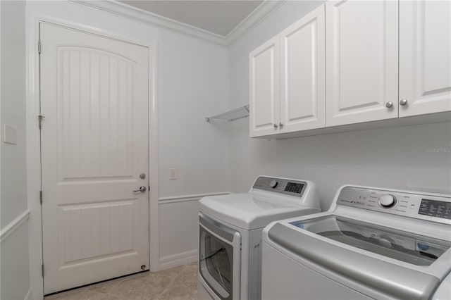 laundry room with cabinet space, crown molding, washer and clothes dryer, and light tile patterned floors