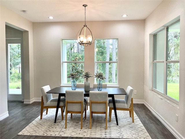 dining space with baseboards, a chandelier, and dark wood finished floors