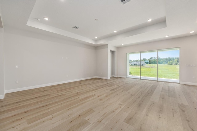 1929 NW 85th Loop, Ocala, FL 34475 - empty room featuring a tray ceiling, recessed lighting, and light wood-style floors