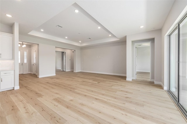 1929 NW 85th Loop, Ocala, FL 34475 - unfurnished bedroom featuring a tray ceiling, recessed lighting, light wood-style flooring, and a chandelier